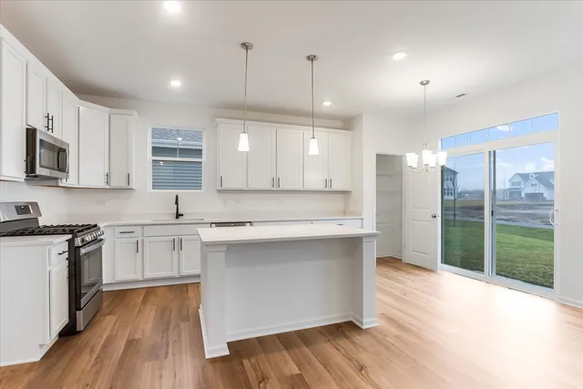 a large kitchen with cabinets wooden floor and stainless steel appliances