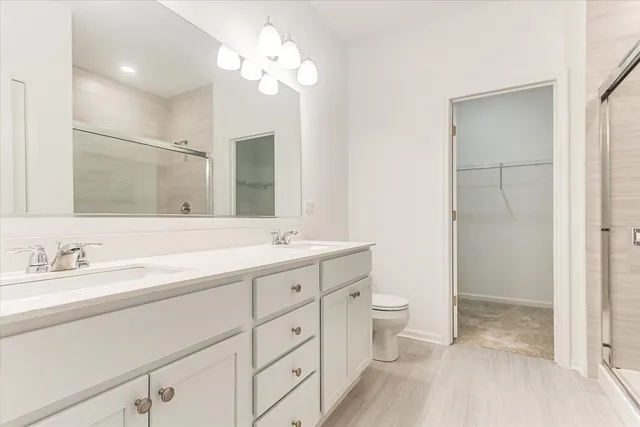 a spacious bathroom with a double vanity sink toilet and shower