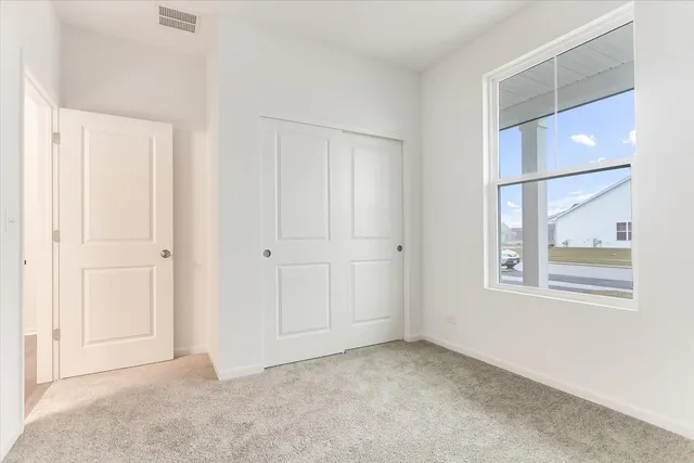an empty room with windows and closet