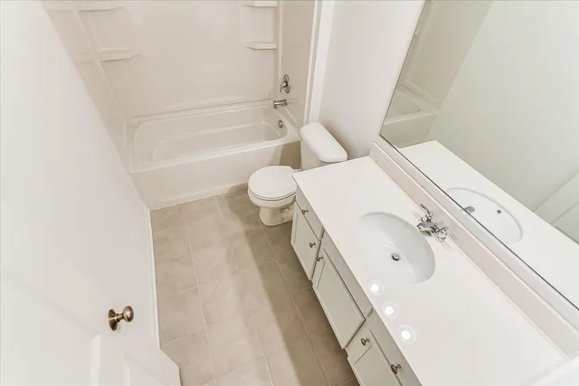 a bathroom with a granite countertop bathtub sink mirror vanity and toilet