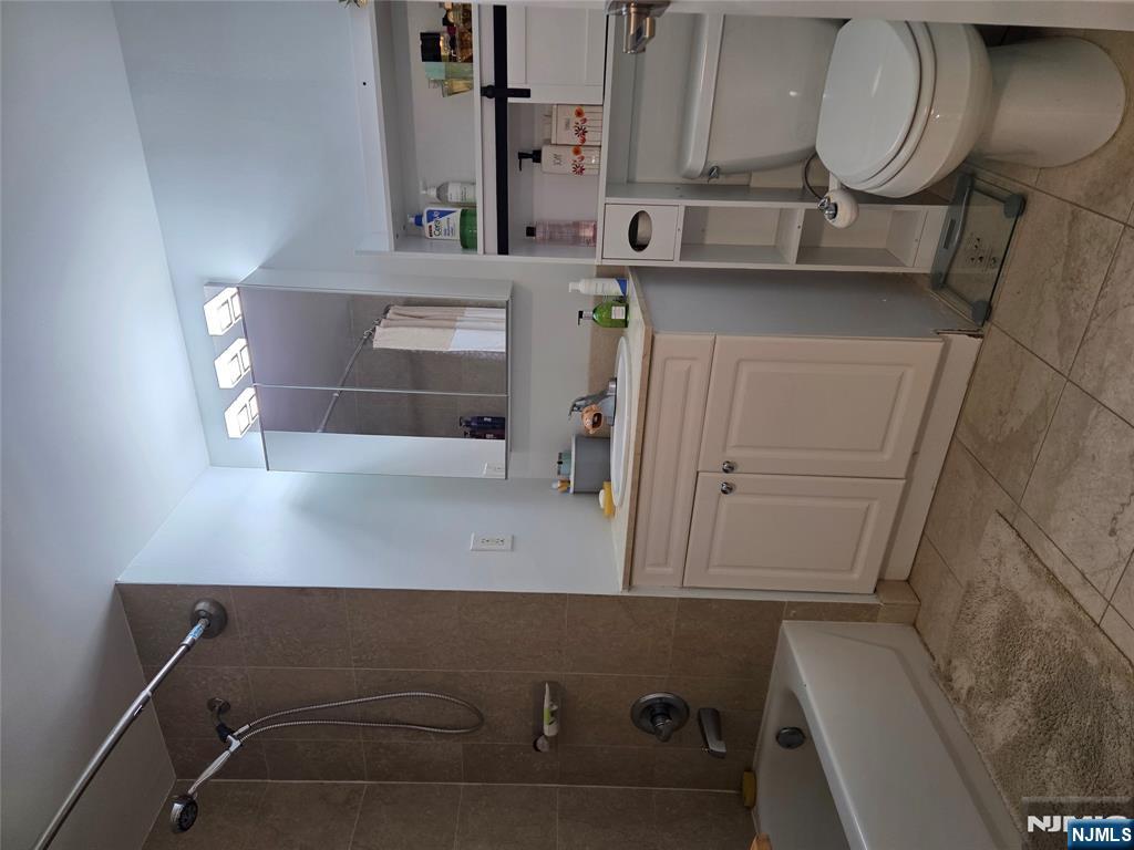 100 Old Palisade Road, Unit 803 Fort Lee, NJ 07024 - Photo 11 of 16 a bathroom with a toilet sink vanity granite tub shower and mirror