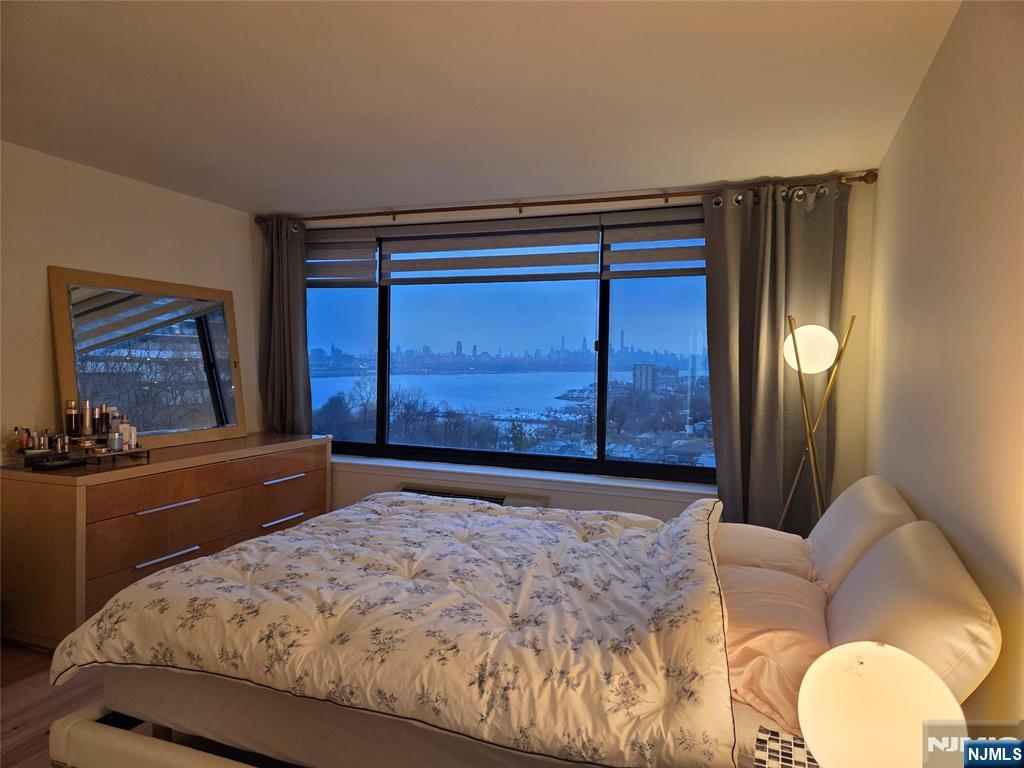 100 Old Palisade Road, Unit 803 Fort Lee, NJ 07024 - Photo 13 of 16 a bedroom with a bed and dresser with mirror