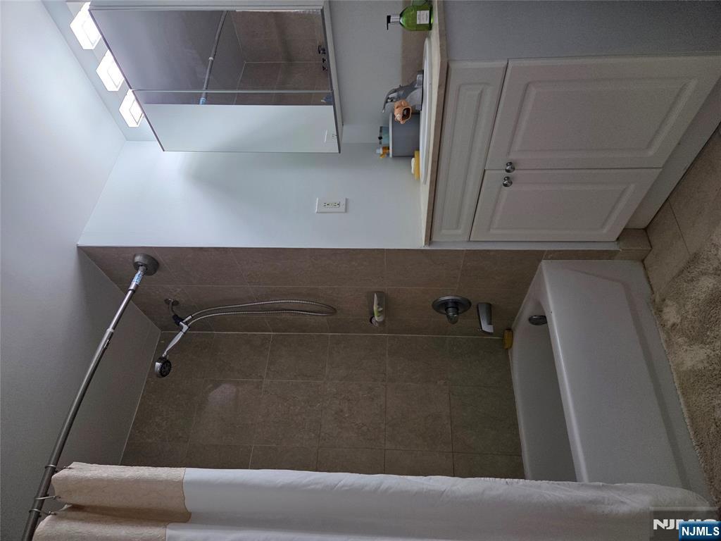 100 Old Palisade Road, Unit 803 Fort Lee, NJ 07024 - Photo 9 of 16 a bathroom with a tub a sink and mirror