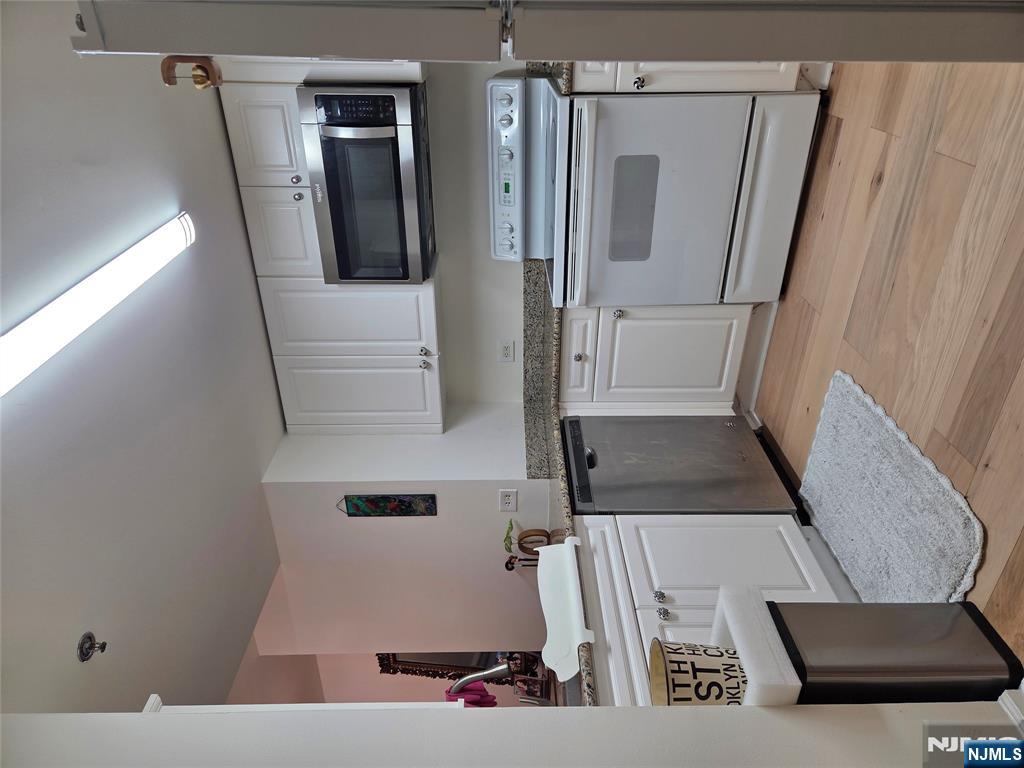 100 Old Palisade Road, Unit 803 Fort Lee, NJ 07024 - Photo 10 of 16 a kitchen with a stove and a microwave