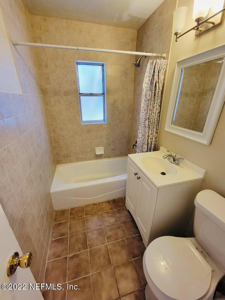289 Las Olas Road St. Augustine, FL 32084 - Photo 8 of 14 a bathroom with a toilet a sink a mirror and bathtub