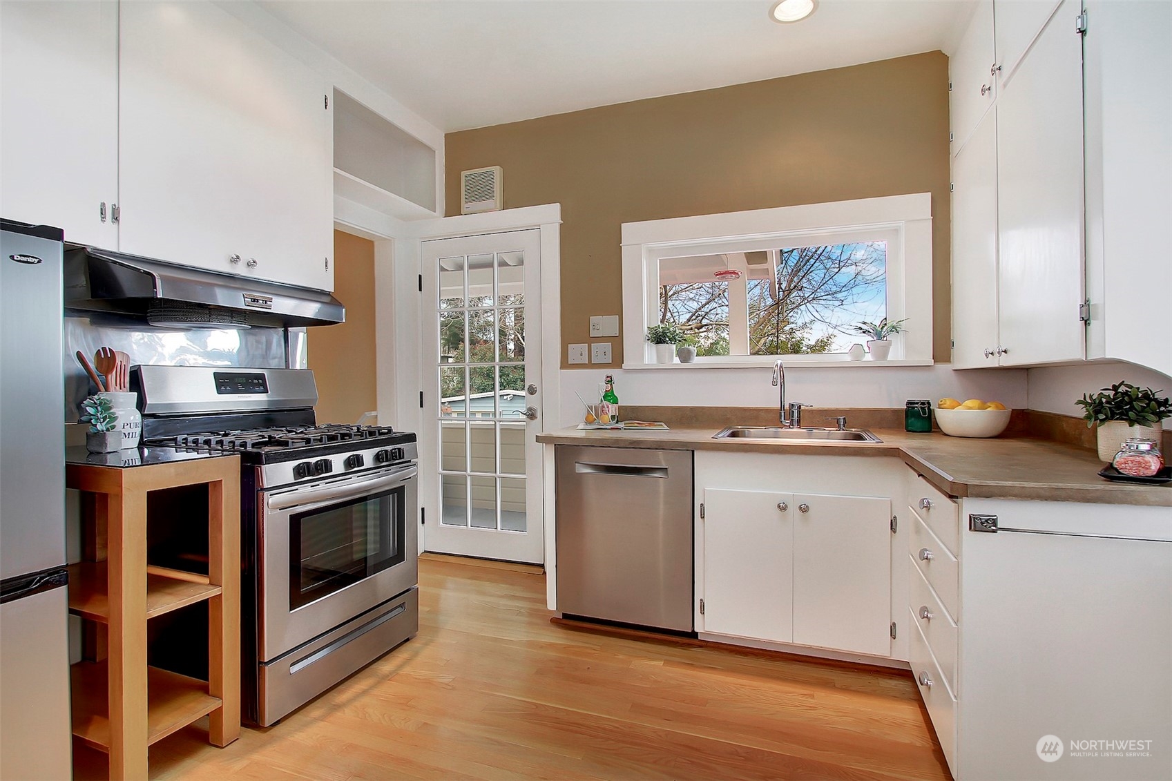 3912 Burke Avenue North Seattle, WA 98103 - Photo 14 of 39 a kitchen with stainless steel appliances granite countertop a stove a sink and a microwave