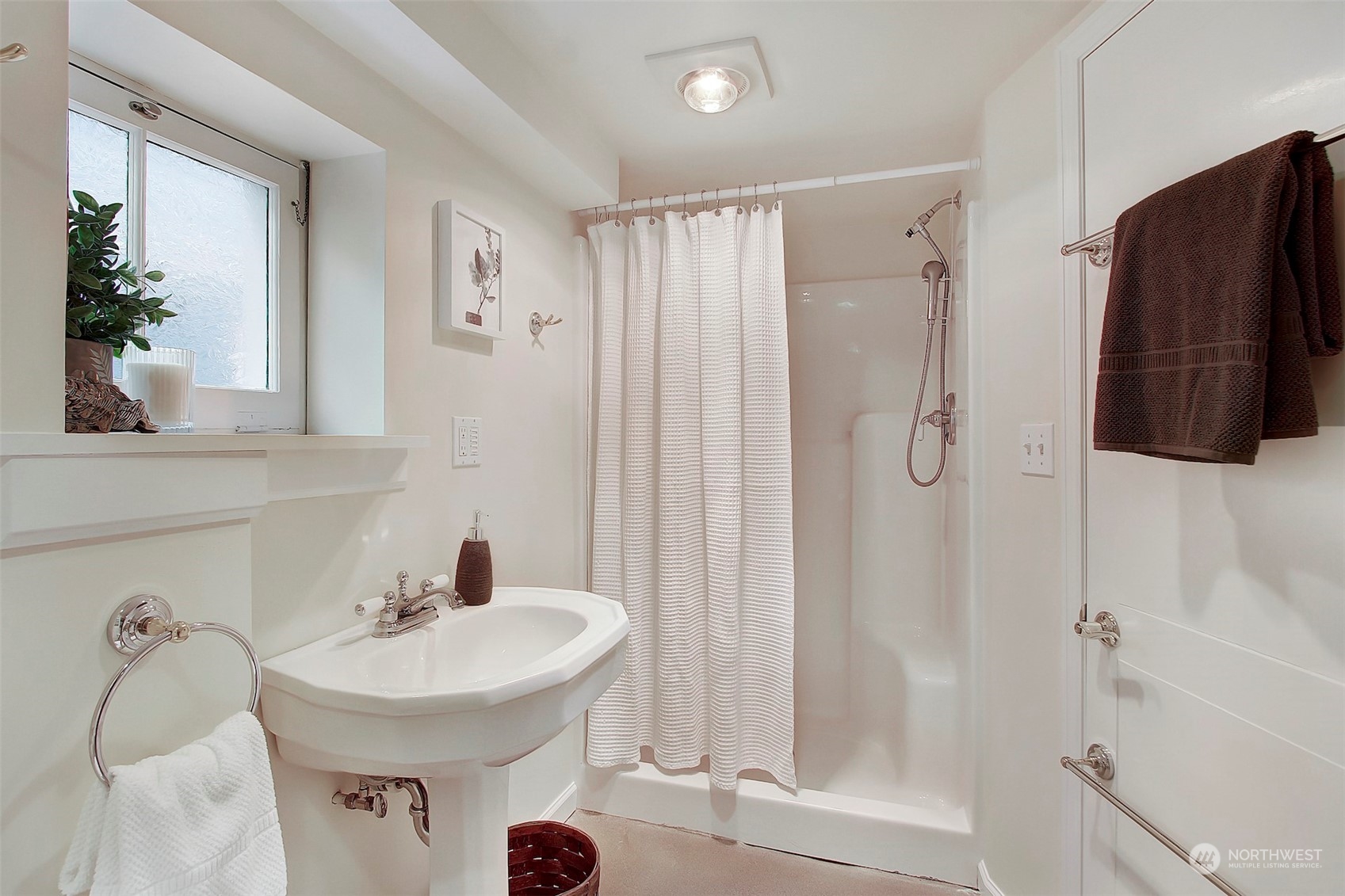 3912 Burke Avenue North Seattle, WA 98103 - Photo 19 of 39 a bathroom with a sink a mirror and a shower