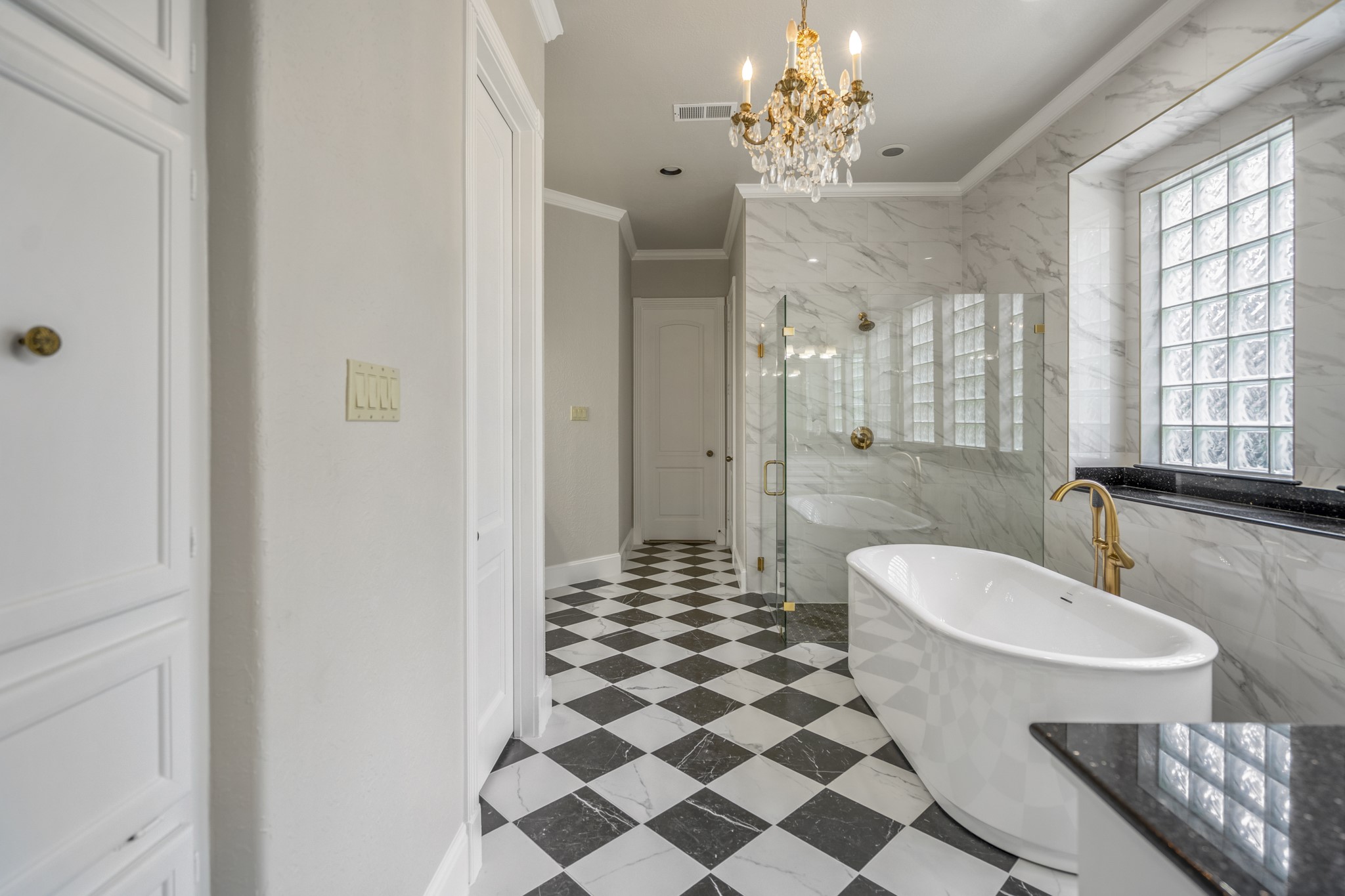 15 Lochbury Court Spring, TX 77379 - Photo 21 of 48 The centerpiece of en-suite bathroom is new updated standalone soaking tub & oversized step-down shower—perfect for unwinding. The elegant gold-toned floor-mounted filler adds a touch of boutique-hotel glamour.