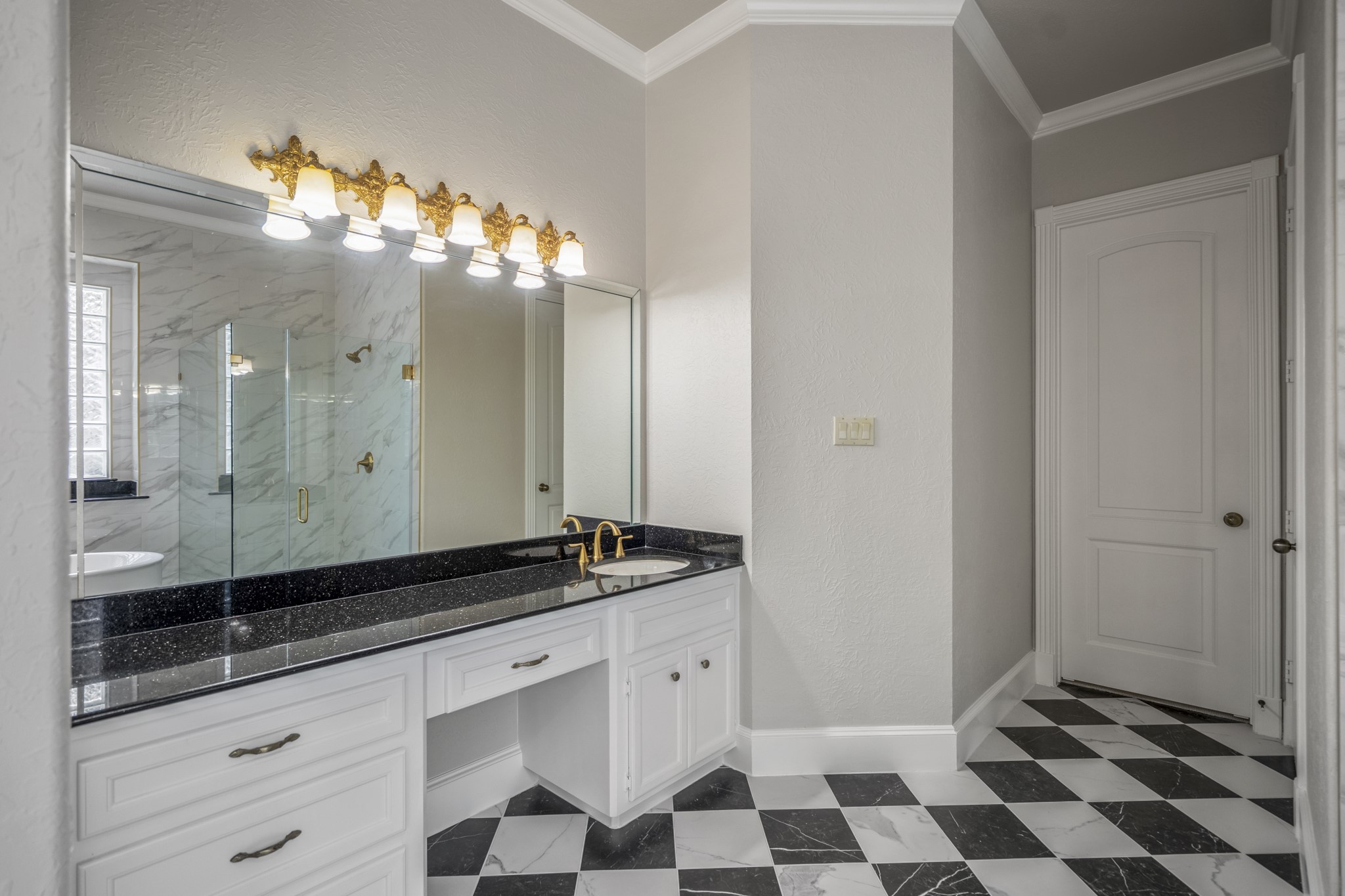 15 Lochbury Court Spring, TX 77379 - Photo 22 of 48 The bold black-and-white marble-patterned floors offer a timeless, high-contrast look that feels both grand and incredibly stylish. Dual sinks and vanity areas on offer for the primary bathroom suite.