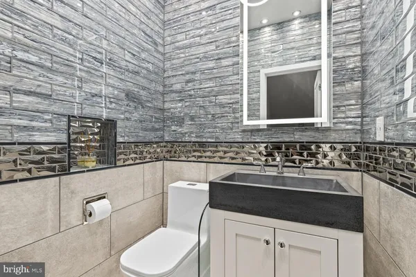 a bathroom with a toilet sink and mirror
