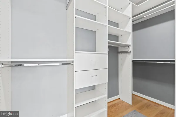 a view of walk in closet with empty racks