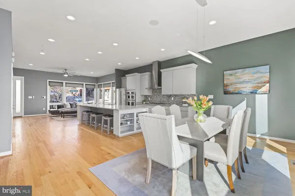 a kitchen with stainless steel appliances kitchen island granite countertop a dining table chairs and granite counter tops