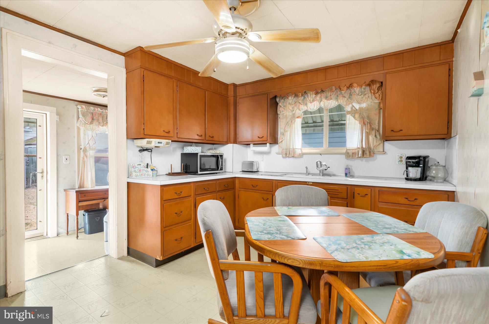 108 Fitzrandolph Avenue Hamilton, NJ 08610 - Photo 9 of 30 a kitchen with stainless steel appliances granite countertop a sink dishwasher a dining table and chairs with wooden floor