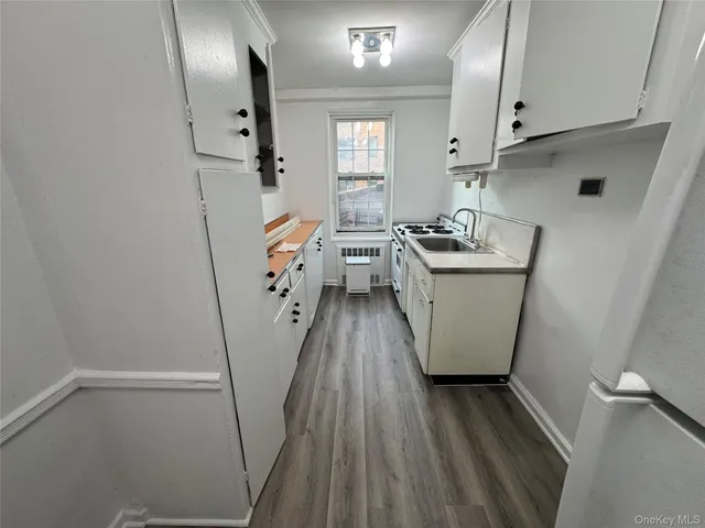 a kitchen with sink a refrigerator and wooden floor