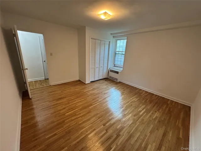 an empty room with wooden floor and mirror