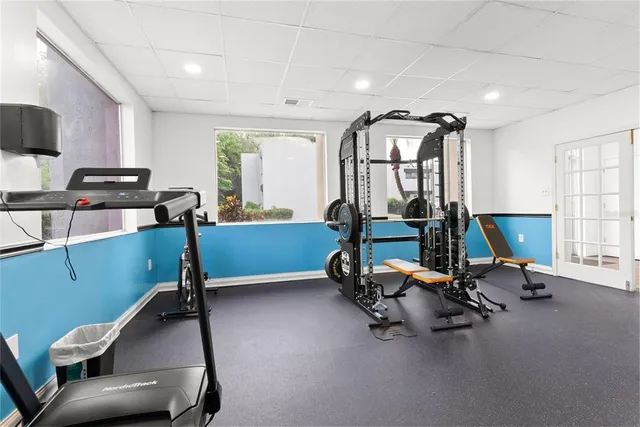 a living room with furniture gym equipment and a large window