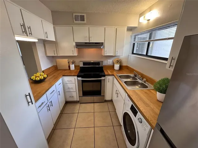 a kitchen with a stove sink and a refrigerator