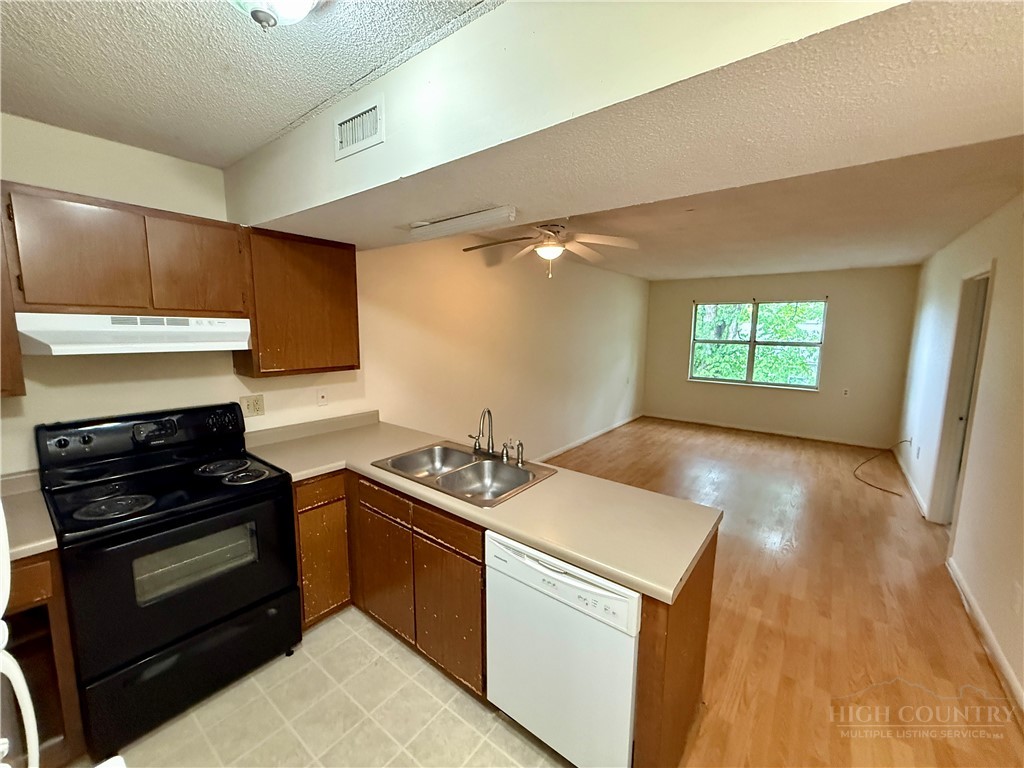 229 East King Street, Unit 30 Boone, NC 28607 - Photo 8 of 19 a kitchen with a stove a sink and a microwave