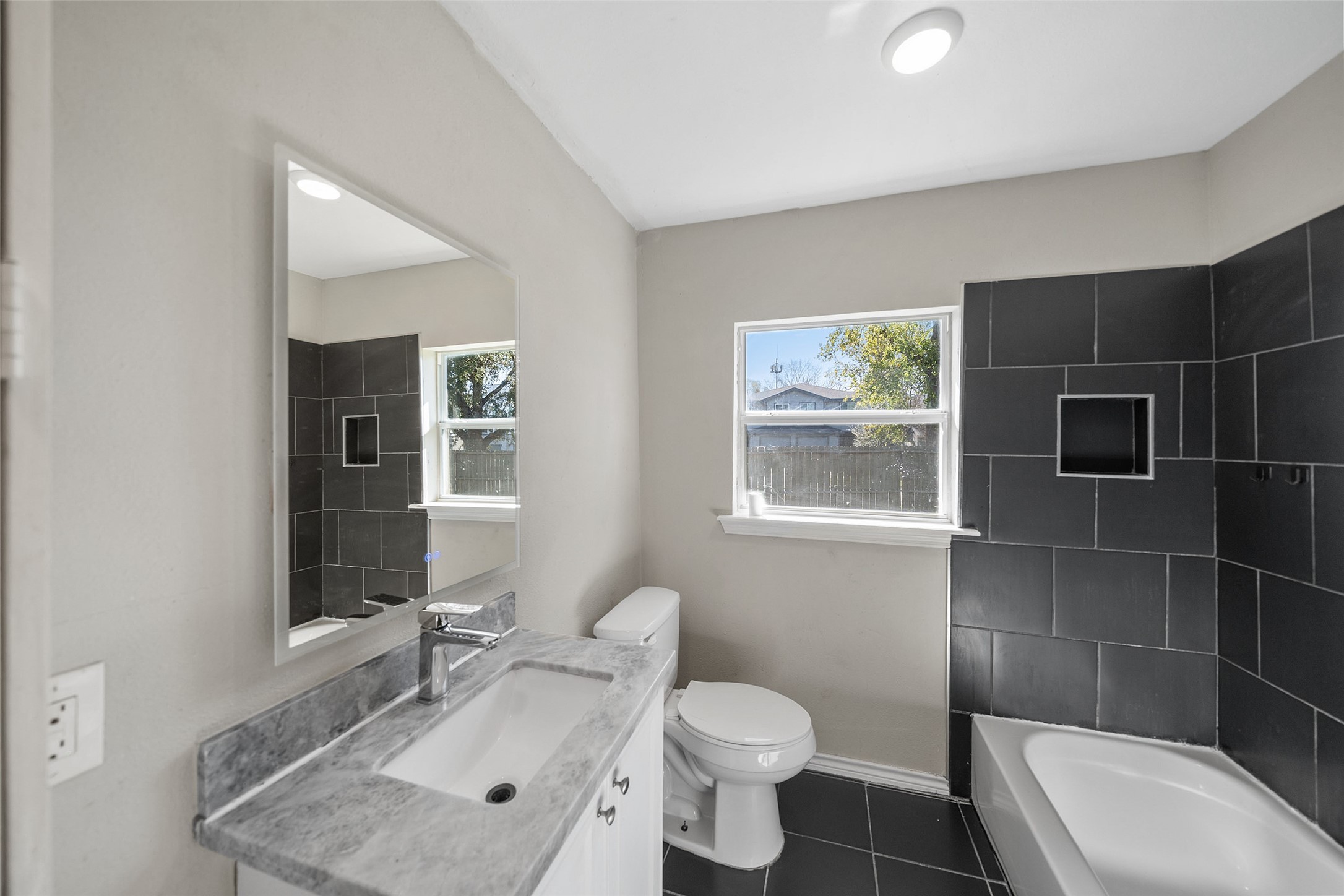 7019 Sur Court Houston, TX 77033 - Photo 20 of 22 a bathroom with a sink toilet a mirror and bathtub