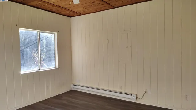 a view of a small space with wooden floor and a window