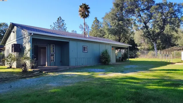 a view of a house with yard and tree s
