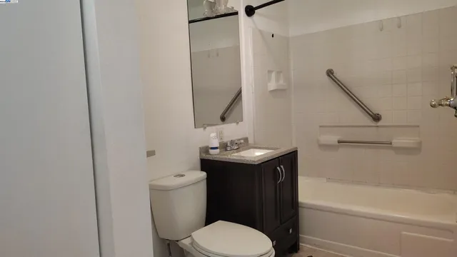a bathroom with a granite countertop toilet sink and mirror