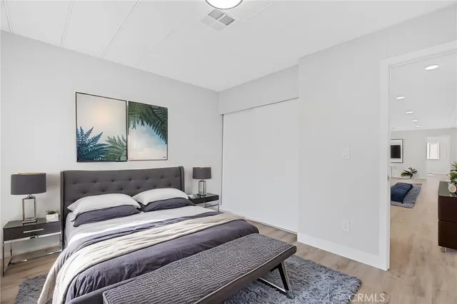 a bedroom with a bed and wooden floor