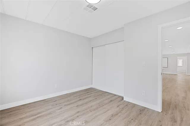 a view of a room with wooden floor and a ceiling fan
