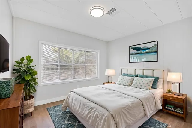 a bedroom with a large bed and a potted plant