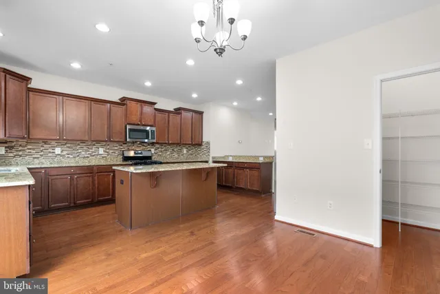 a kitchen with a refrigerator sink cabinets and a wooden floor