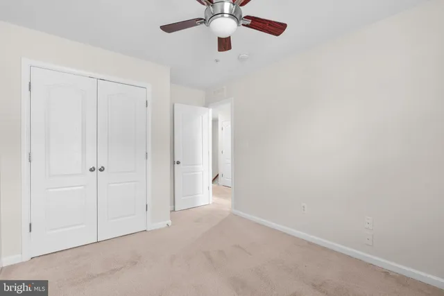 an empty room with chandelier fan