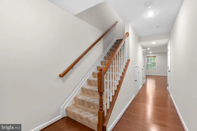 a view of a hallway with wooden floor and entryway