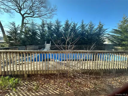 a view of backyard with table and chairs and wooden fence