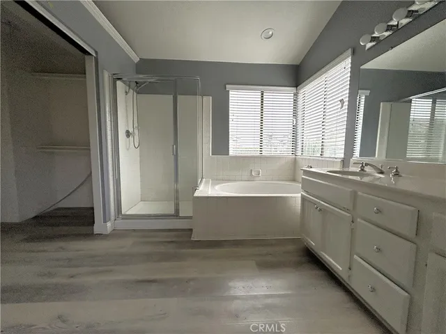 a bathroom with a tub sink shower and mirror