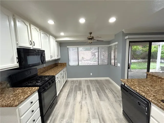a kitchen with granite countertop a stove sink and cabinets