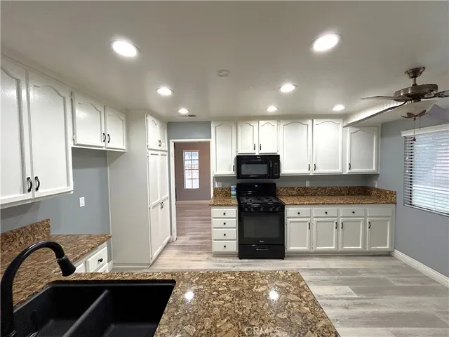 a kitchen with granite countertop a stove and cabinets