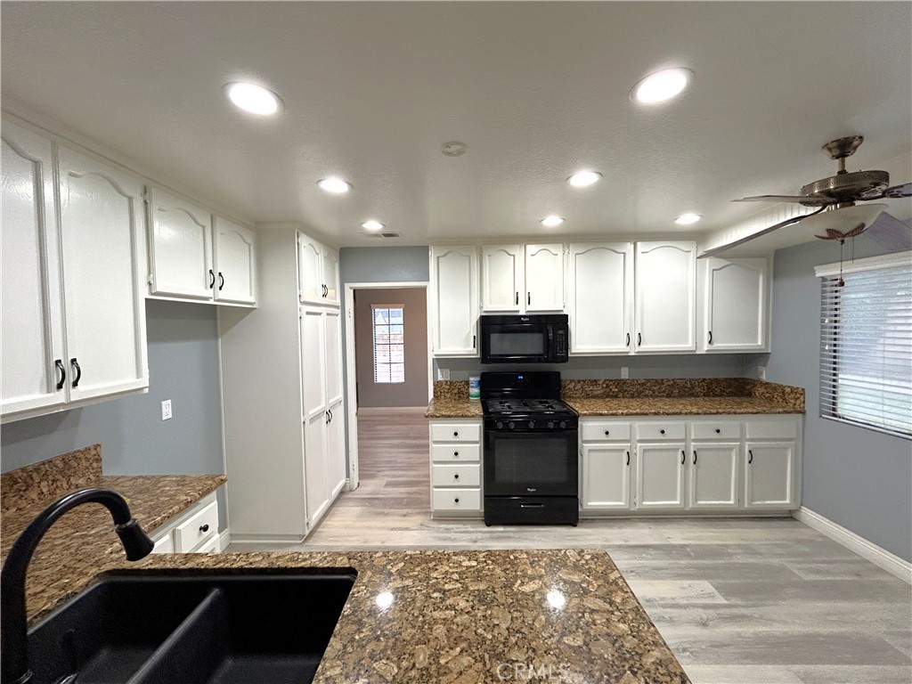 3773 Burning Tree Drive Ontario, CA 91761 - Photo 5 of 28 a kitchen with granite countertop a stove and cabinets