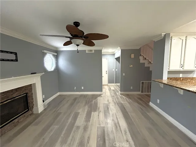 a view of wooden floor a chandelier and a fireplace in room
