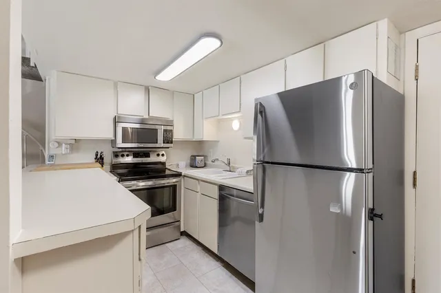 a white refrigerator freezer and a stove sitting inside of a kitchen