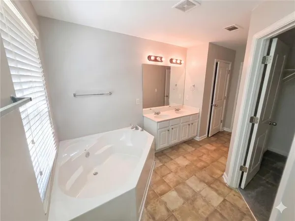 a bathroom with a tub sink and a mirror