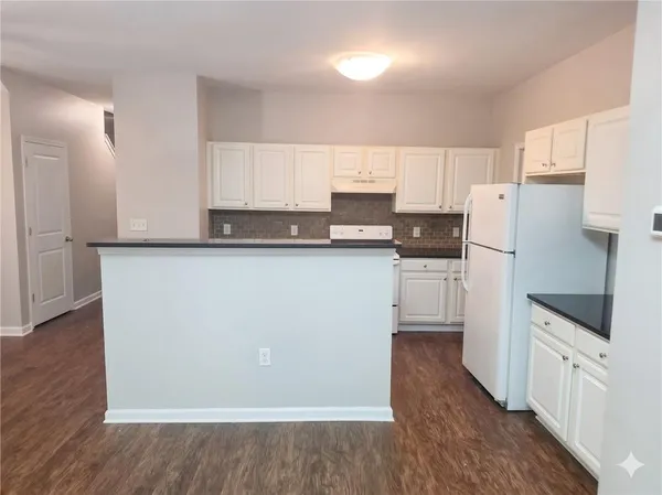 a kitchen with white cabinets and white appliances