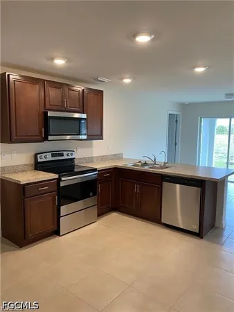 a kitchen with stainless steel appliances granite countertop a stove a sink and a microwave