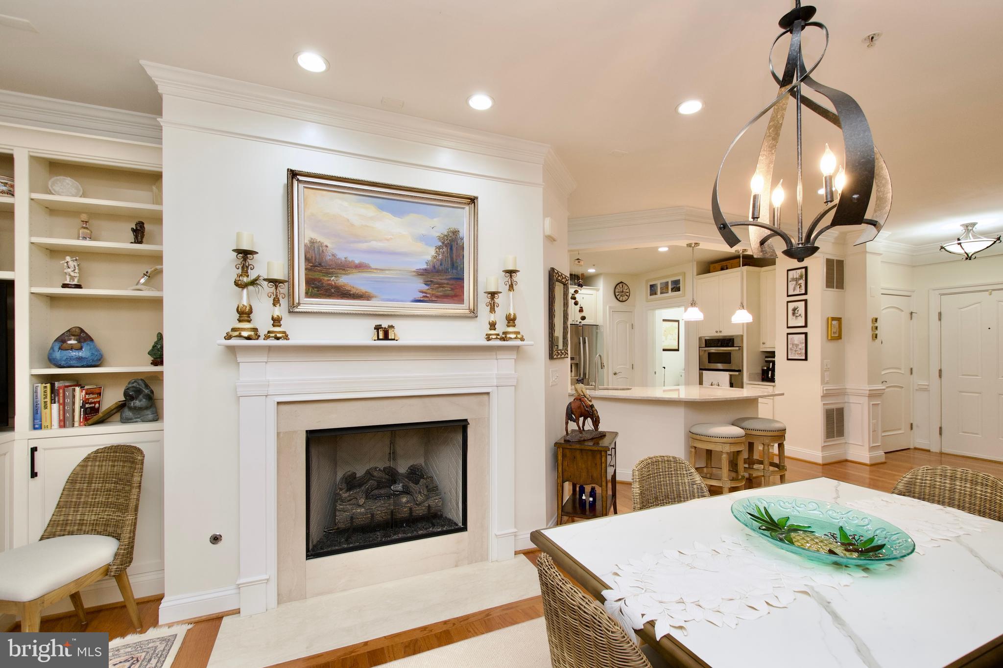 1781 Chain Bridge Road, Unit 302 McLean, VA 22102 - Photo 4 of 39 a living room with furniture a fireplace and kitchen view