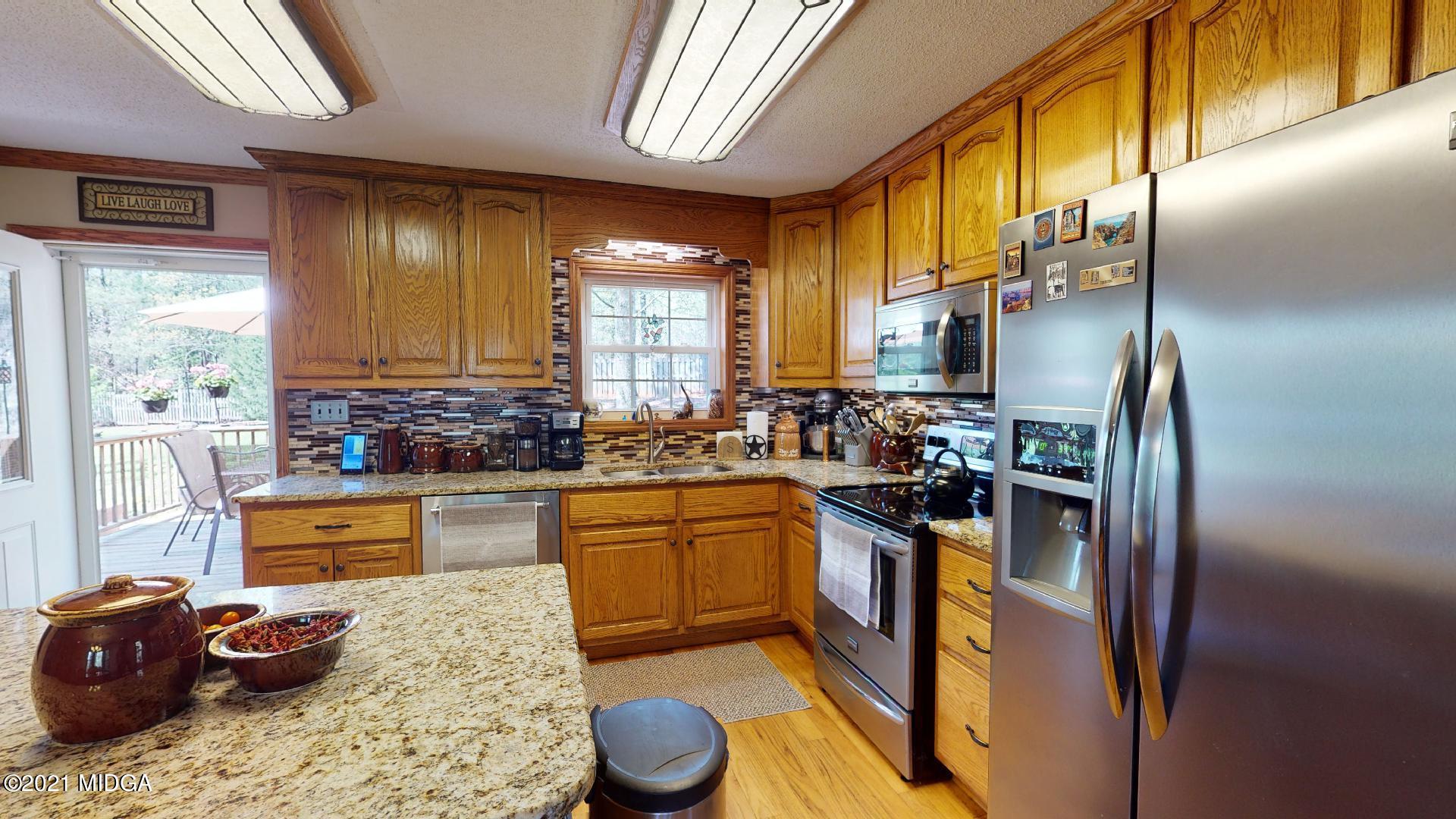 1534 Smith Road Forsyth, GA 31029 - Photo 7 of 25 a kitchen with stainless steel appliances granite countertop a sink stove and refrigerator