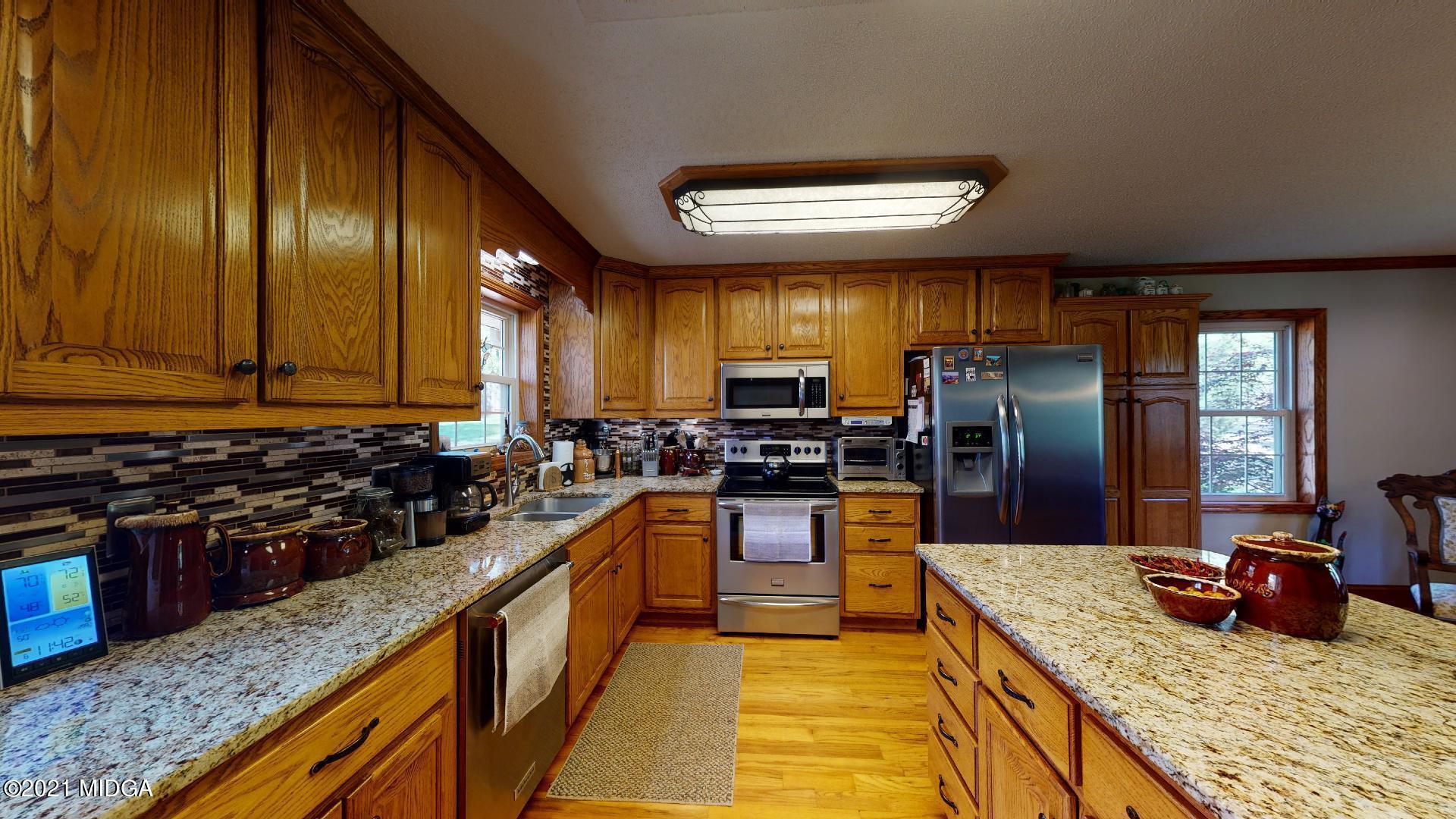 1534 Smith Road Forsyth, GA 31029 - Photo 8 of 25 a kitchen with stainless steel appliances granite countertop a stove a refrigerator a sink and dishwasher