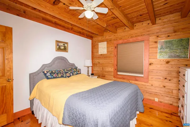 a bedroom with a bed and a painting on the wall