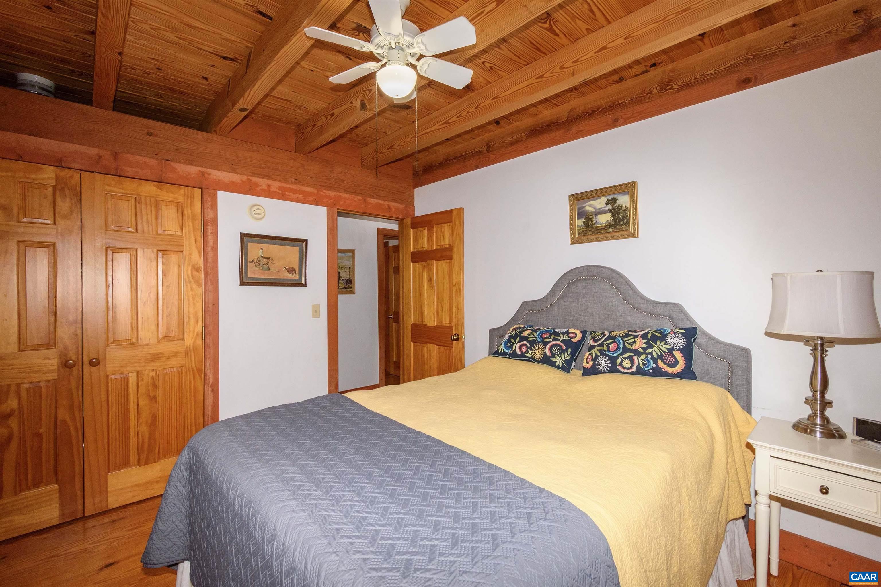 11441 Old Lawyers Road Unionville, VA 22567 - Photo 15 of 45 a bedroom with a bed and a chandelier