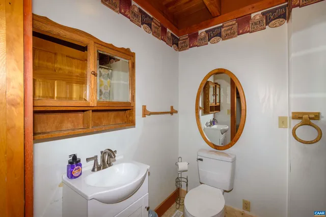 a bathroom with a toilet a sink and a mirror