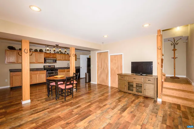a kitchen with stainless steel appliances granite countertop a sink a stove and a wooden floors