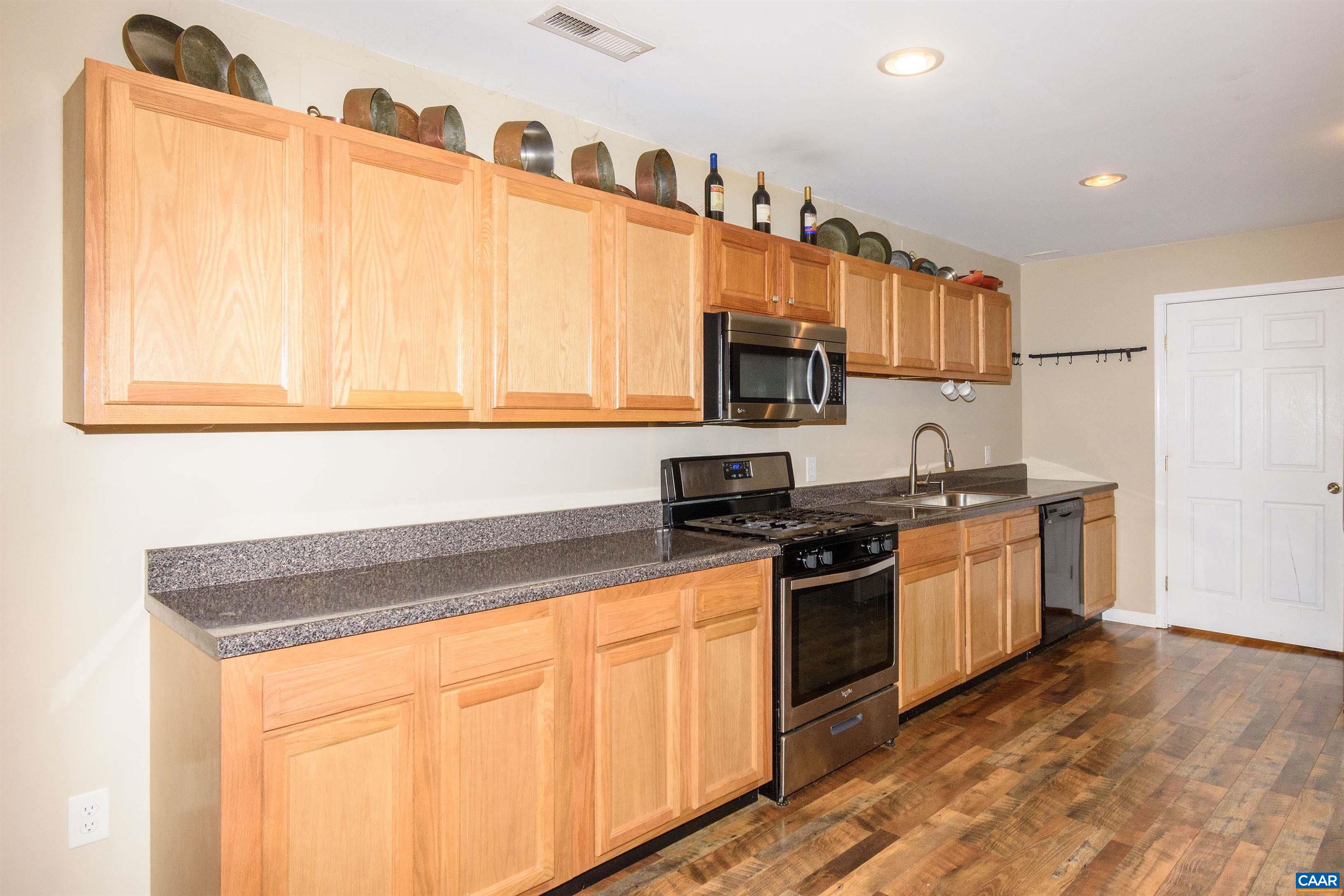11441 Old Lawyers Road Unionville, VA 22567 - Photo 34 of 45 a kitchen with stainless steel appliances granite countertop a stove a sink and a microwave